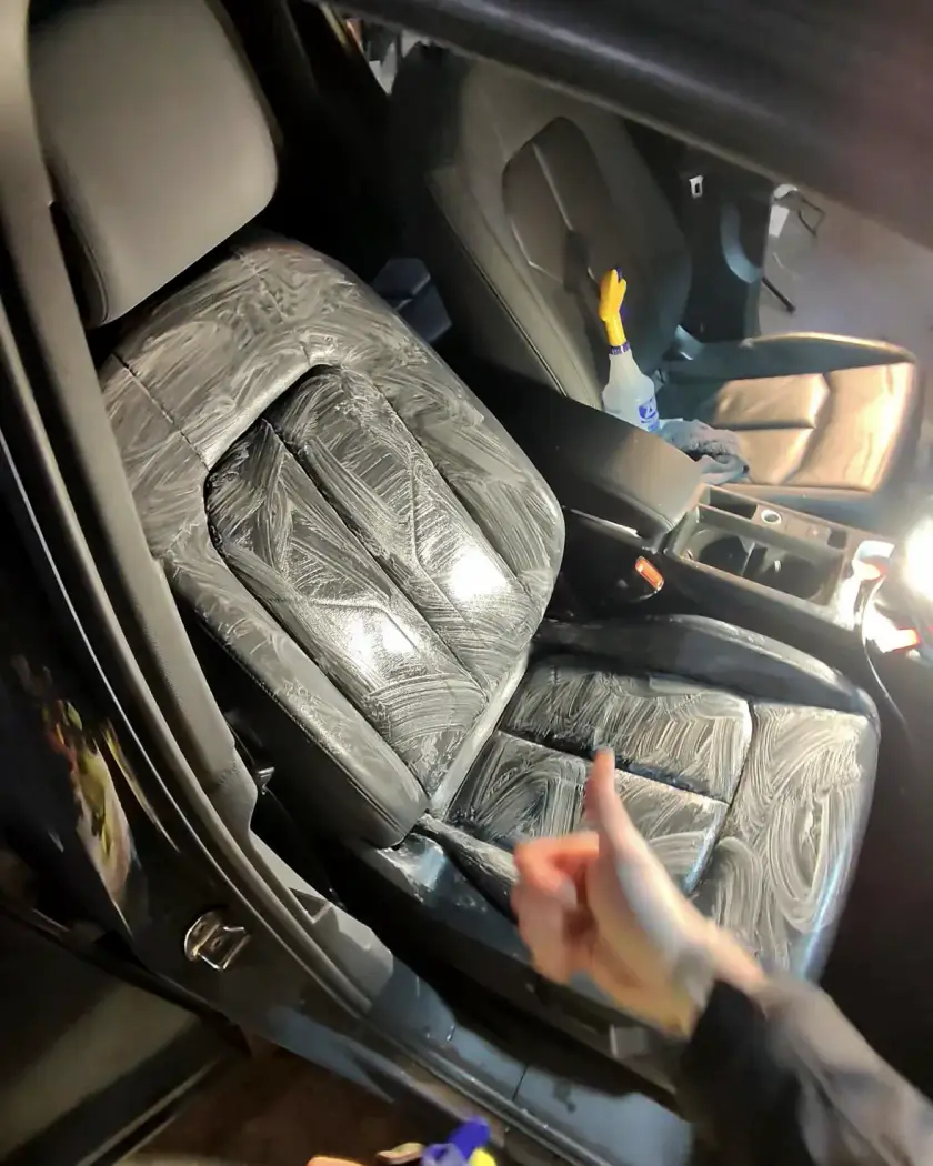 Front leather seat covered in cleaning foam during an interior detail