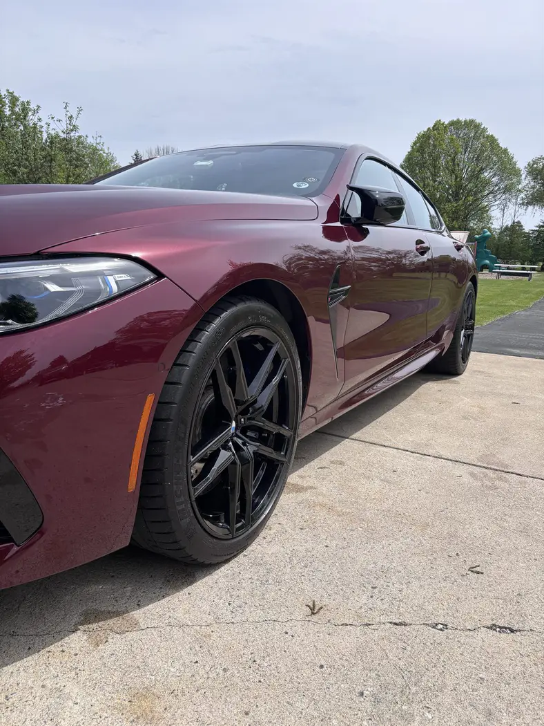 Glossy burgundy BMW after an exterior detail, side profile