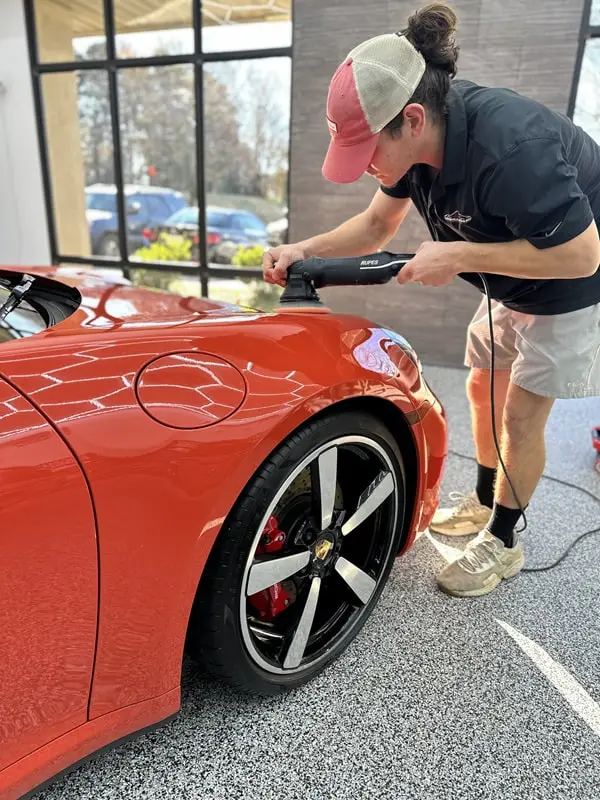 Paint correction polishing on an orange Porsche 911 at Greenville Detailing in Greenville, SC
