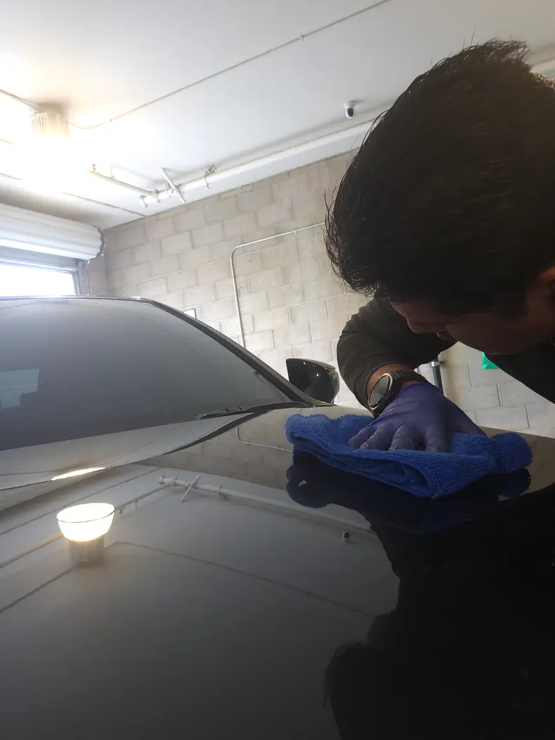 Arturo inspecting the paint finish and reflection after polishing in Riverside, CA