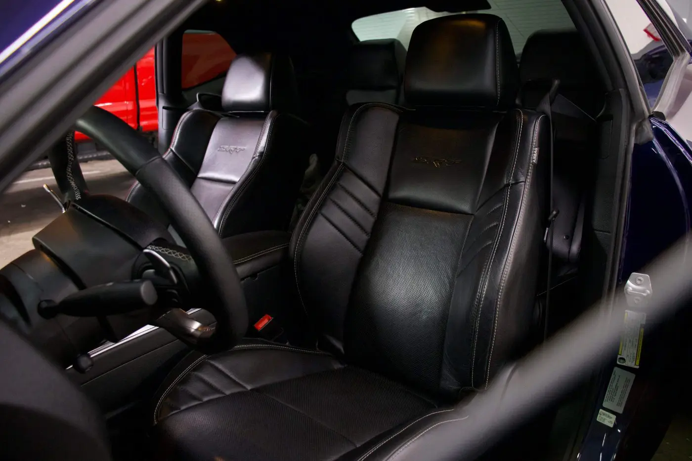A cleaned and conditioned black leather seat in a vehicle interior