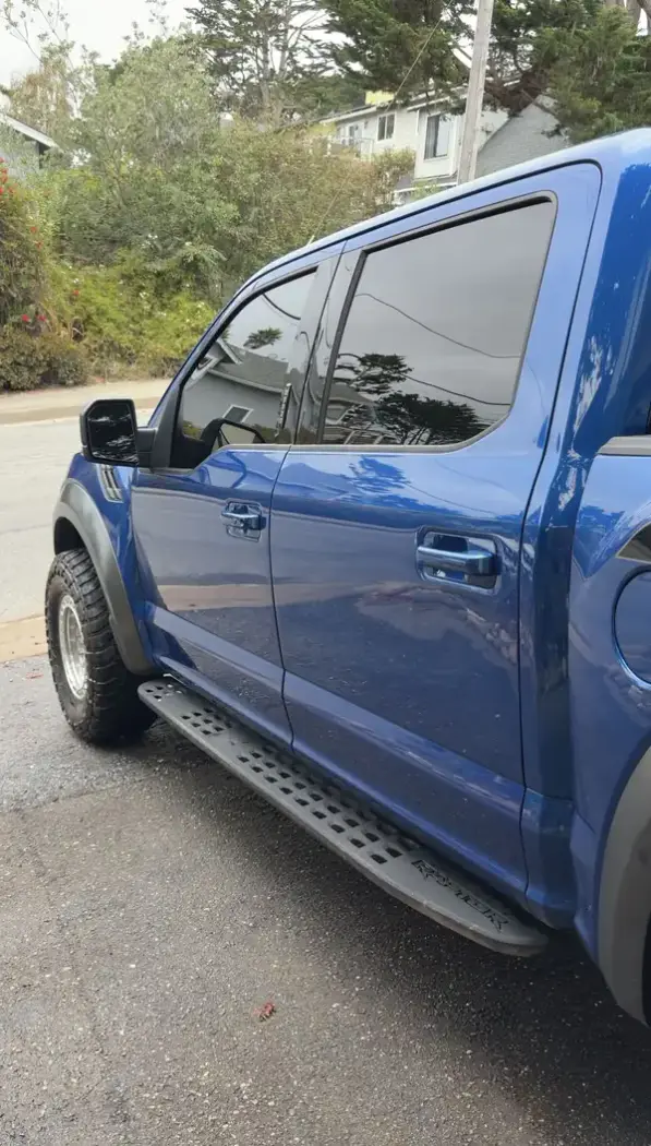 Clean driver's side of a blue Ford F-150 Raptor after a mobile detail