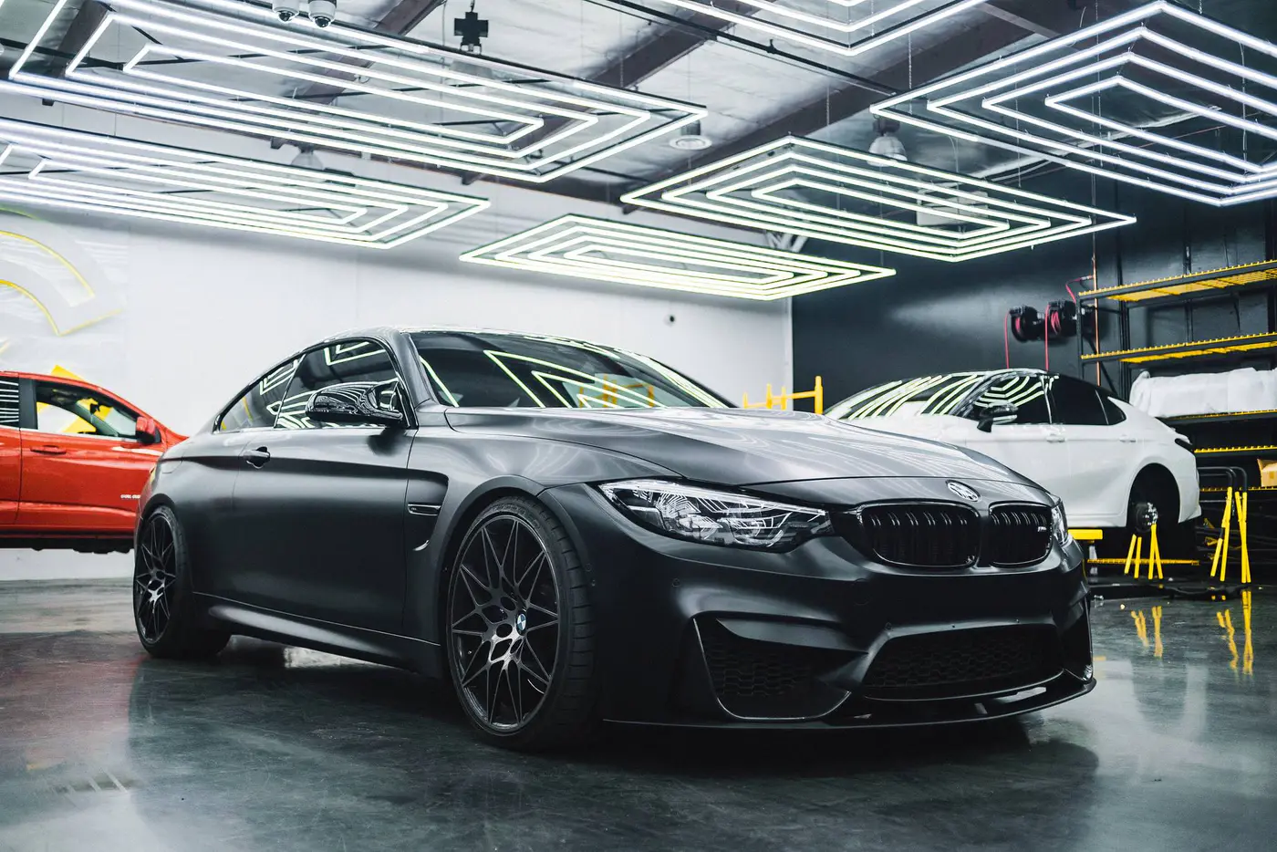 Luxury black car showcased in modern garage — Seattle Dent & Detail paint correction