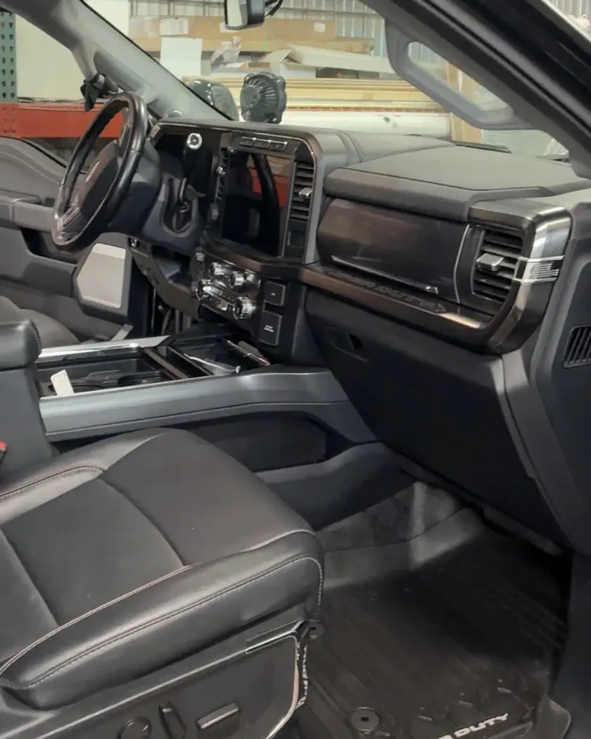 Clean cab of a black Ford Super Duty, leather seats and floor mats