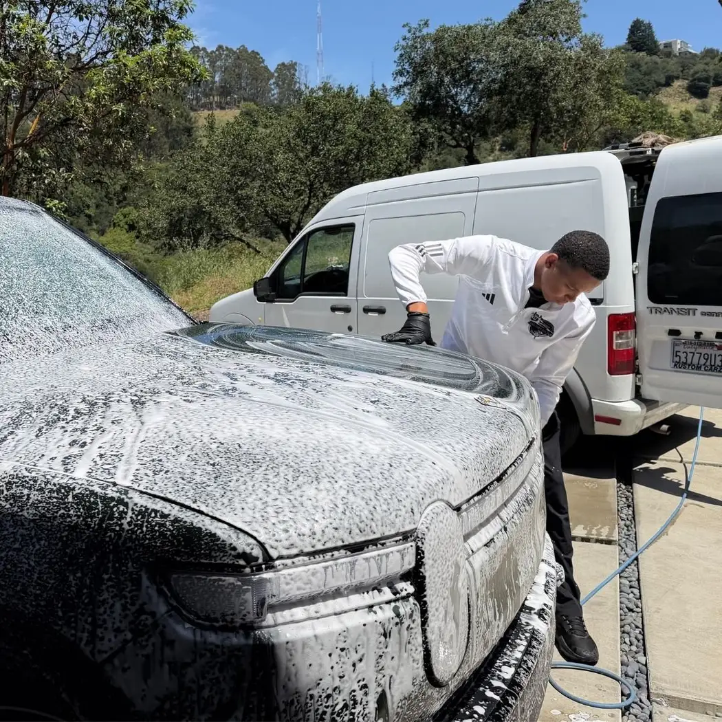 Foam pre-soak on a white sedan during a mobile exterior detail