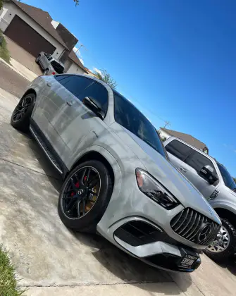 Grey Mercedes-AMG GLE SUV gleaming after a full exterior detail in a driveway under blue sky