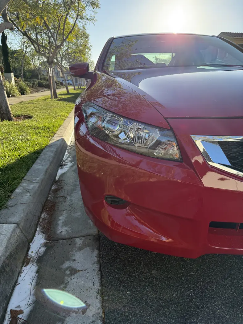 Same Honda Accord after paint correction and headlight restoration — deep red shine and crystal-clear headlights