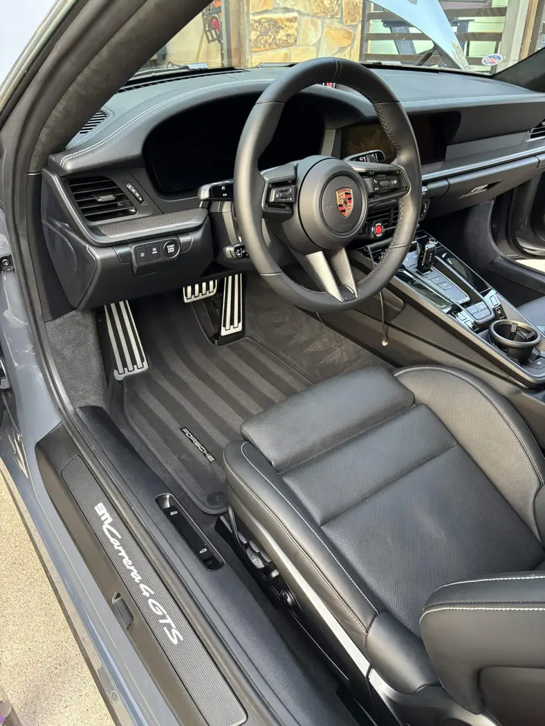 Porsche 911 Carrera 4 GTS black leather interior with contrast stitching and illuminated sill after an interior detail
