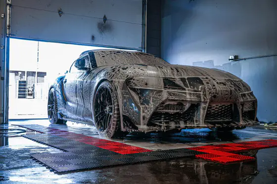 A sports car covered in protective film during clear bra installation