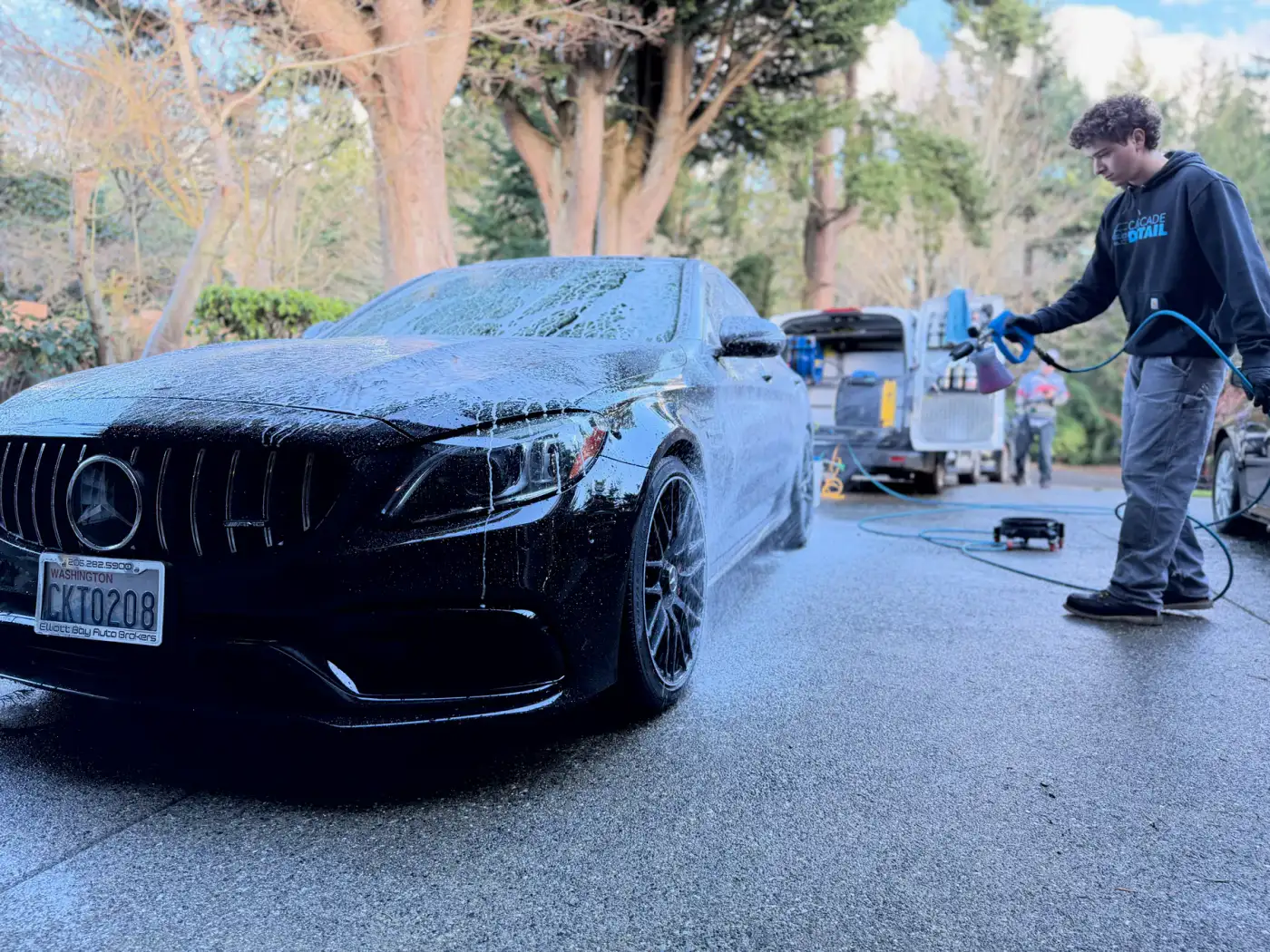 Ethan from Cascade Detail washing a black Mercedes-AMG
