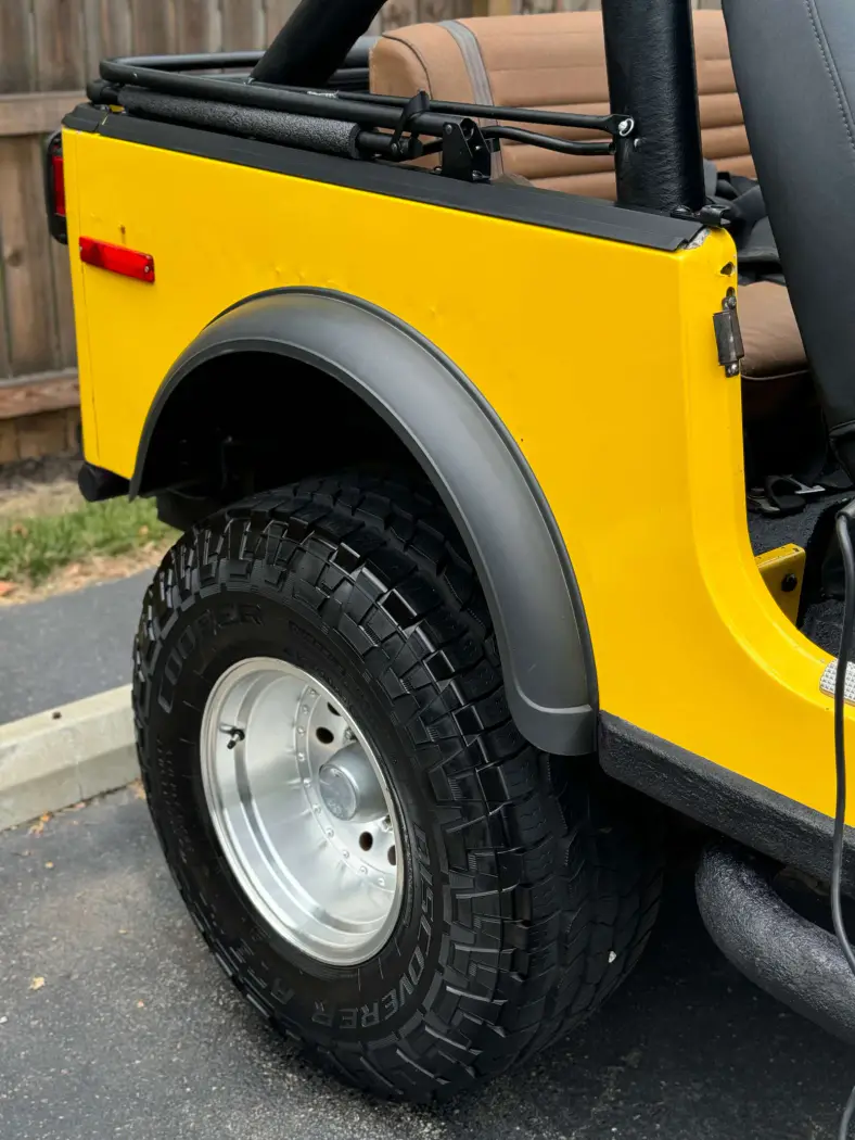 Yellow Jeep fender and tire restored to a clean, polished finish after professional exterior detailing in Fort Wayne, Indiana.
