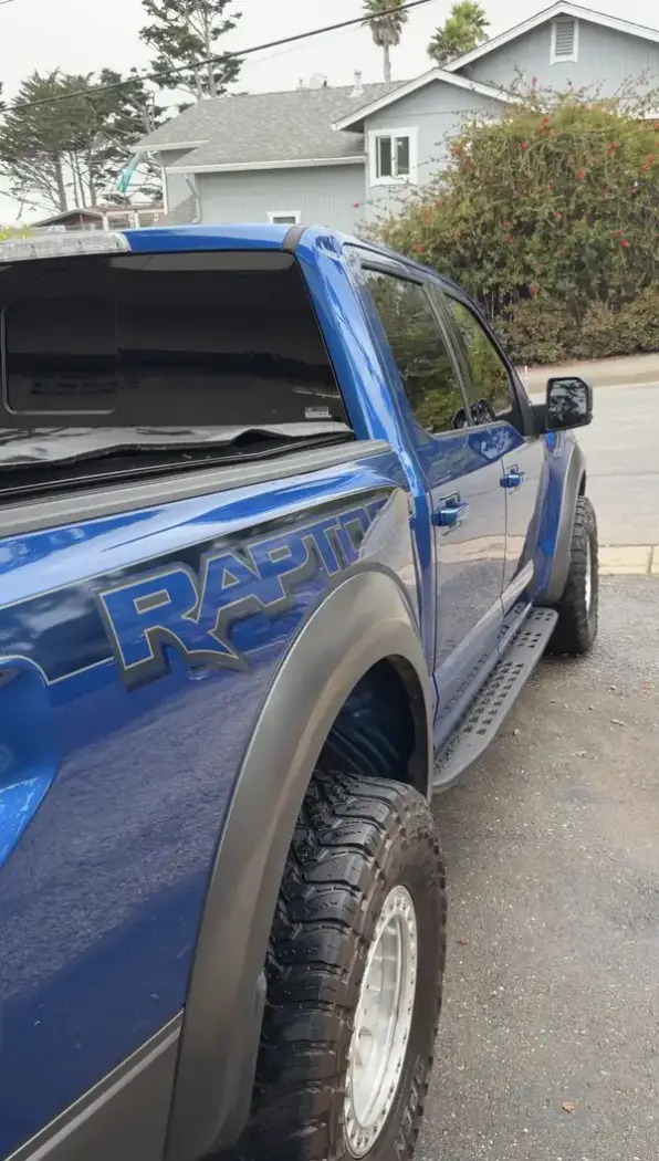 Clean RAPTOR bedside graphic and wheel on a blue Ford F-150 after detailing